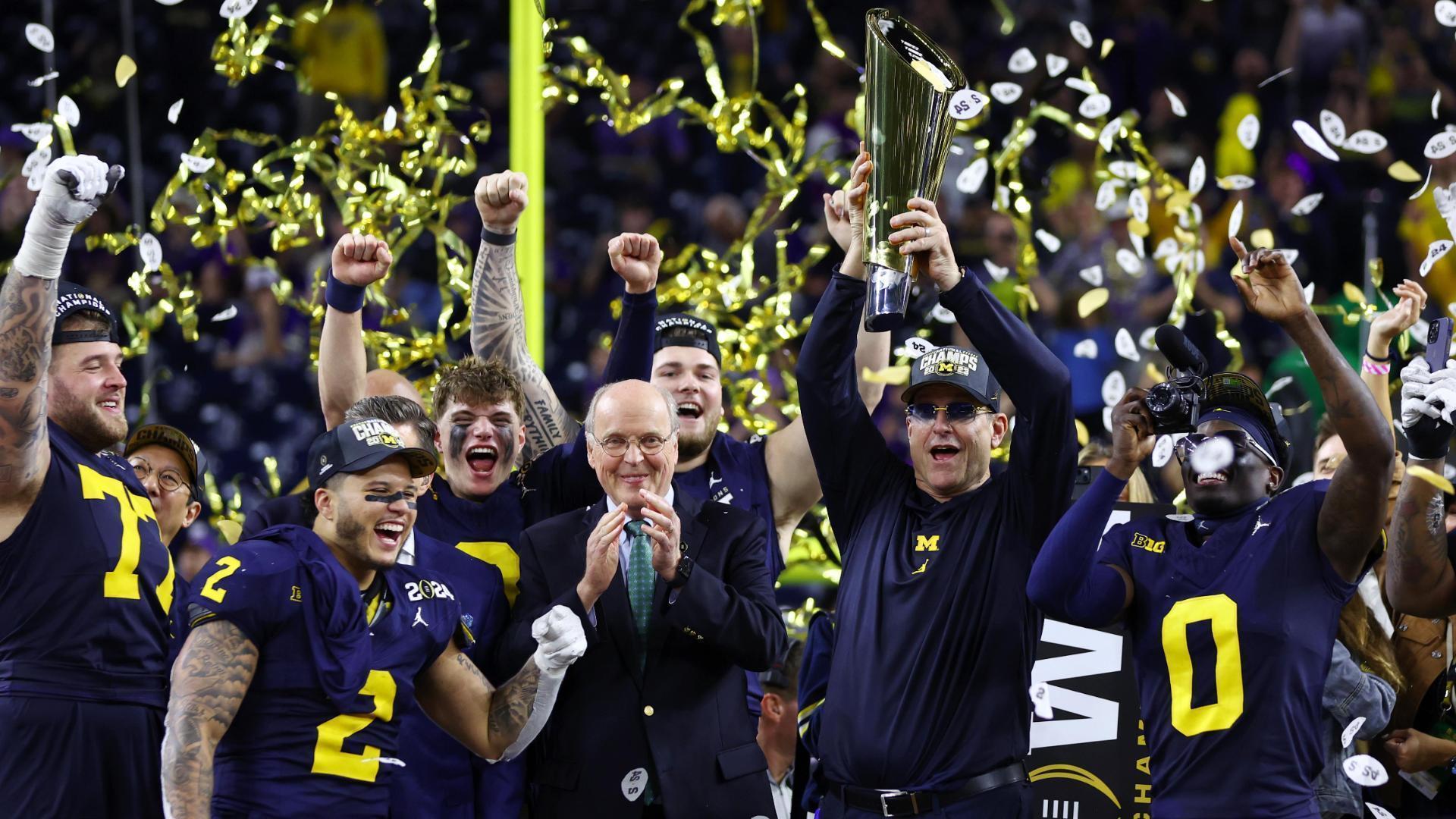 Jim Harbaugh lifts the trophy as Michigan celebrates title