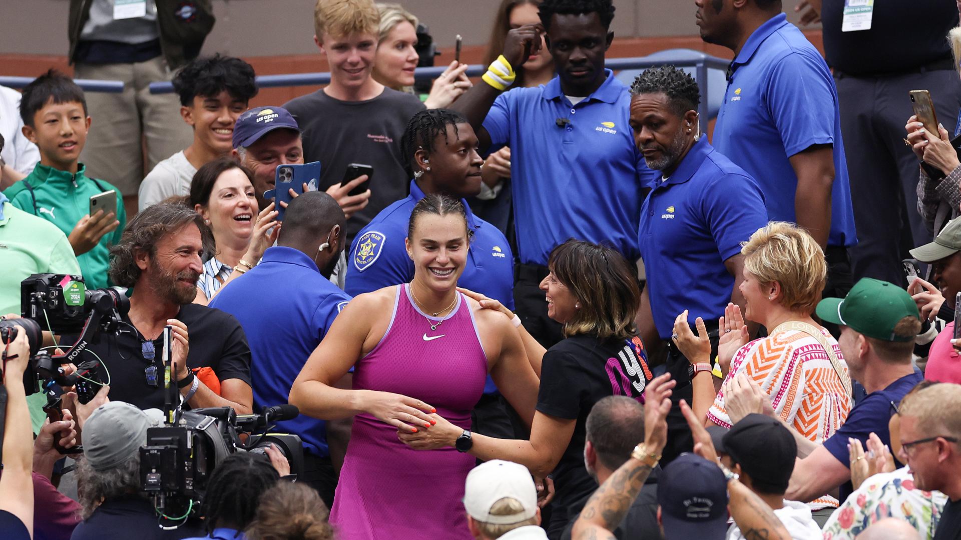 Sabalenka high-fives fans while walking to her box to celebrate