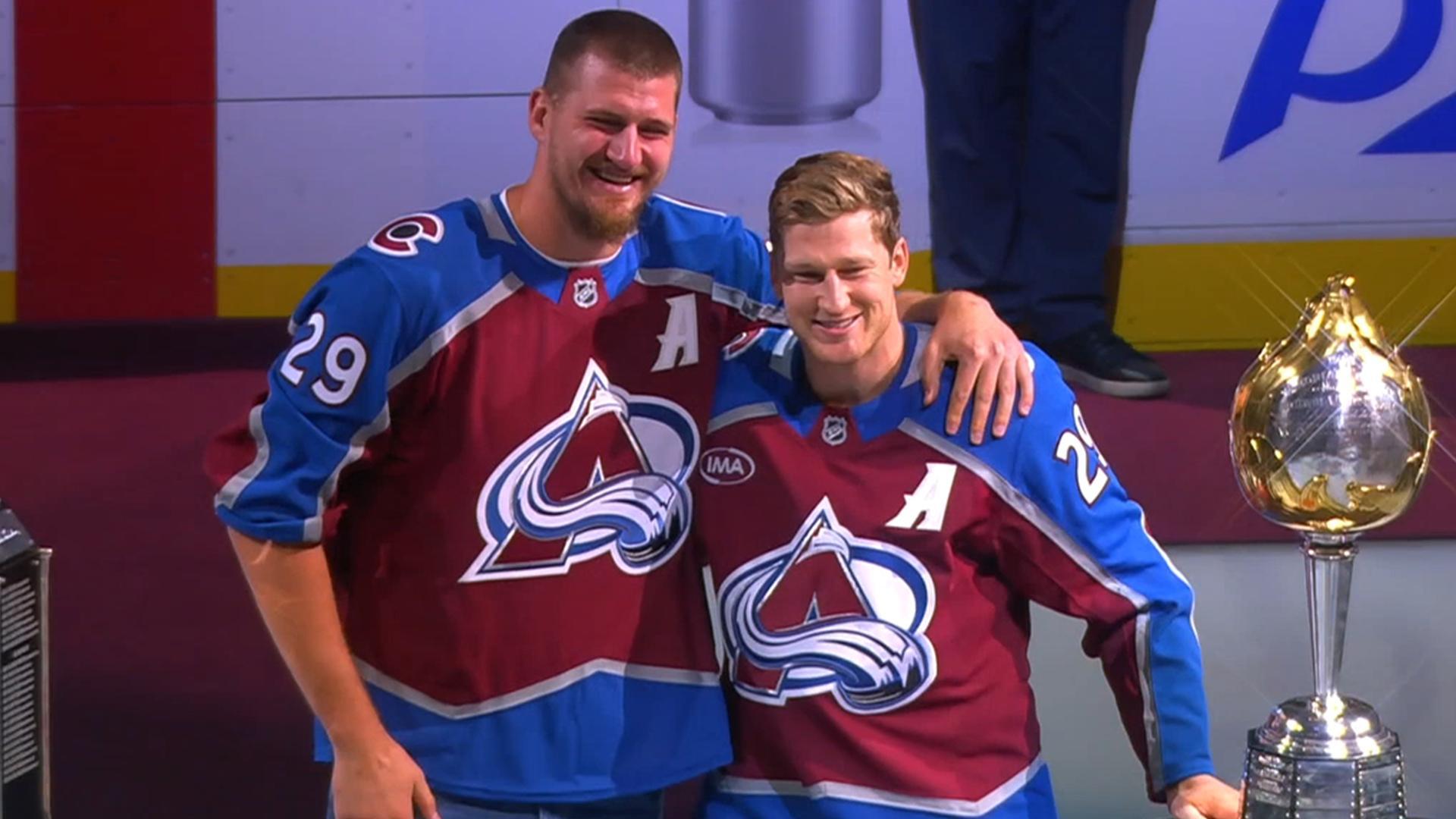 Nikola Jokic presents Nathan MacKinnon with the Hart trophy