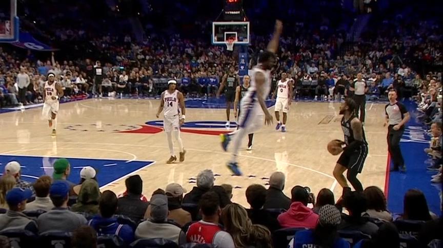 Joel Embiid goes flying into the crowd after a block attempt