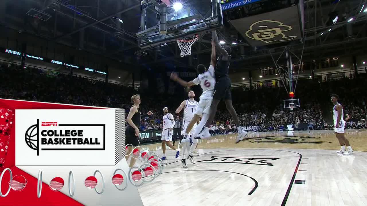 Colorado's Bangot Dak puts a Kansas defender on an alley-oop poster