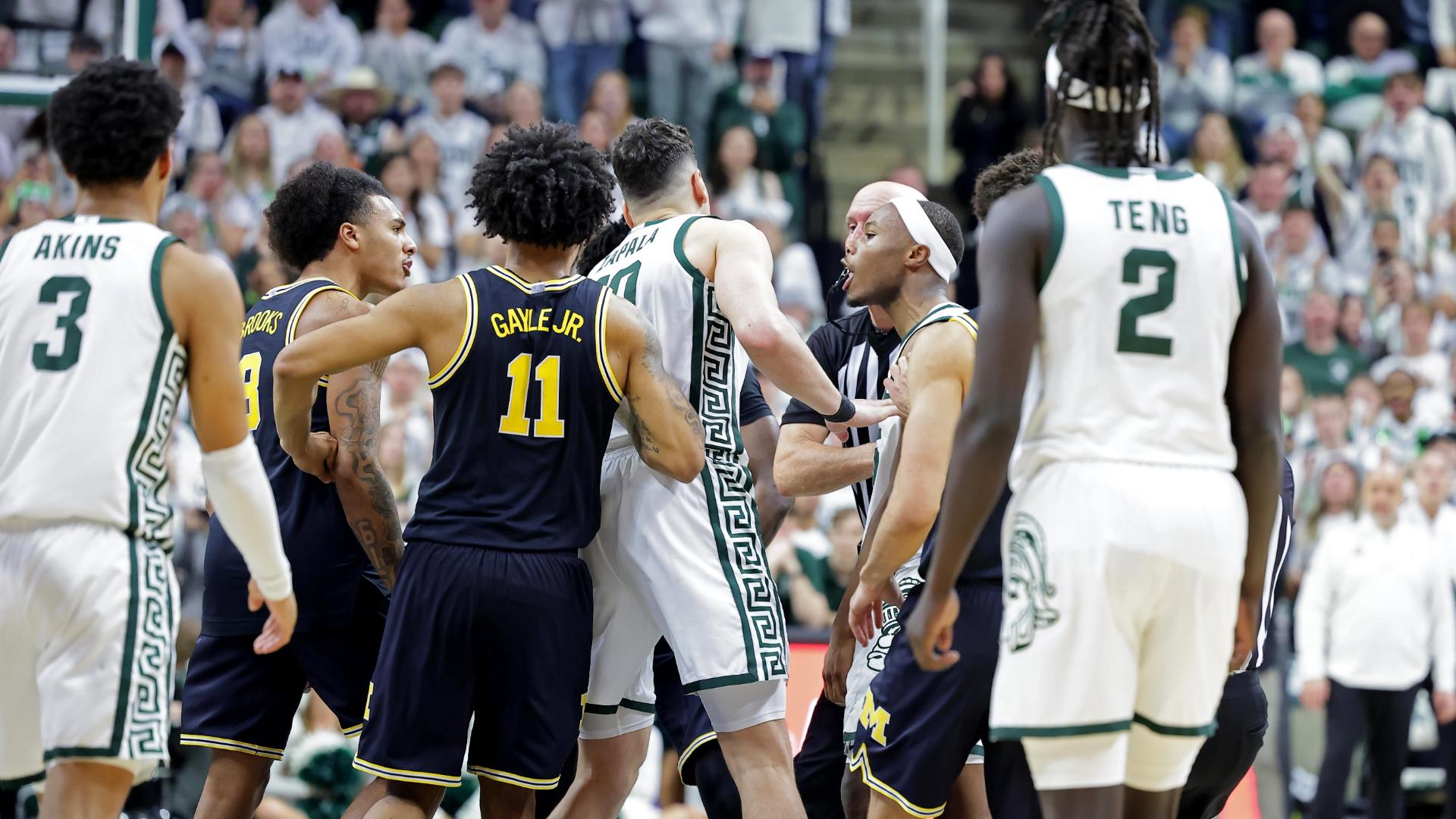 Tre Holloman initiates scuffle with Michigan players standing on logo