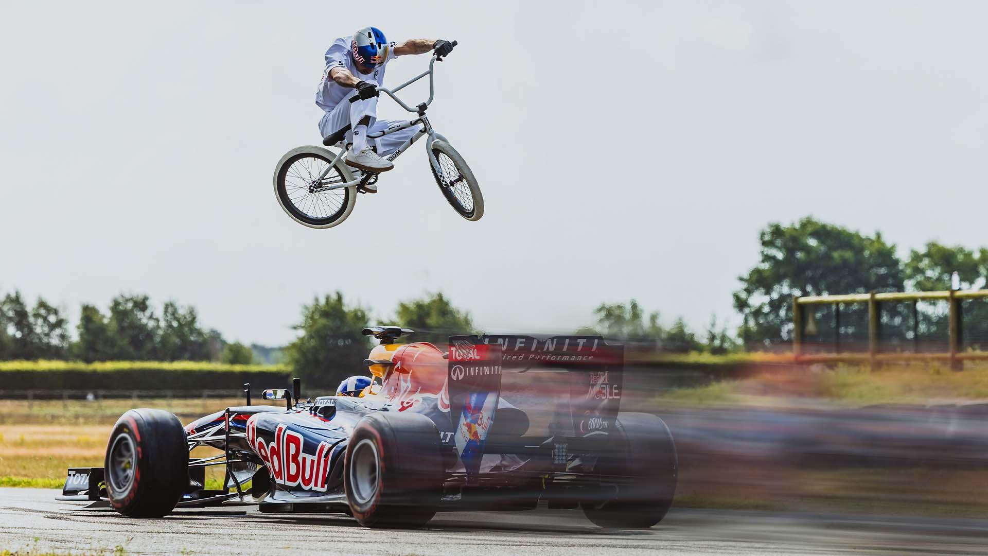 BMX legend Kriss Kyle tries to jump over a moving F1 car