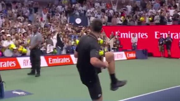 Novak Djokovic fakes throwing a pitch with a tennis ball