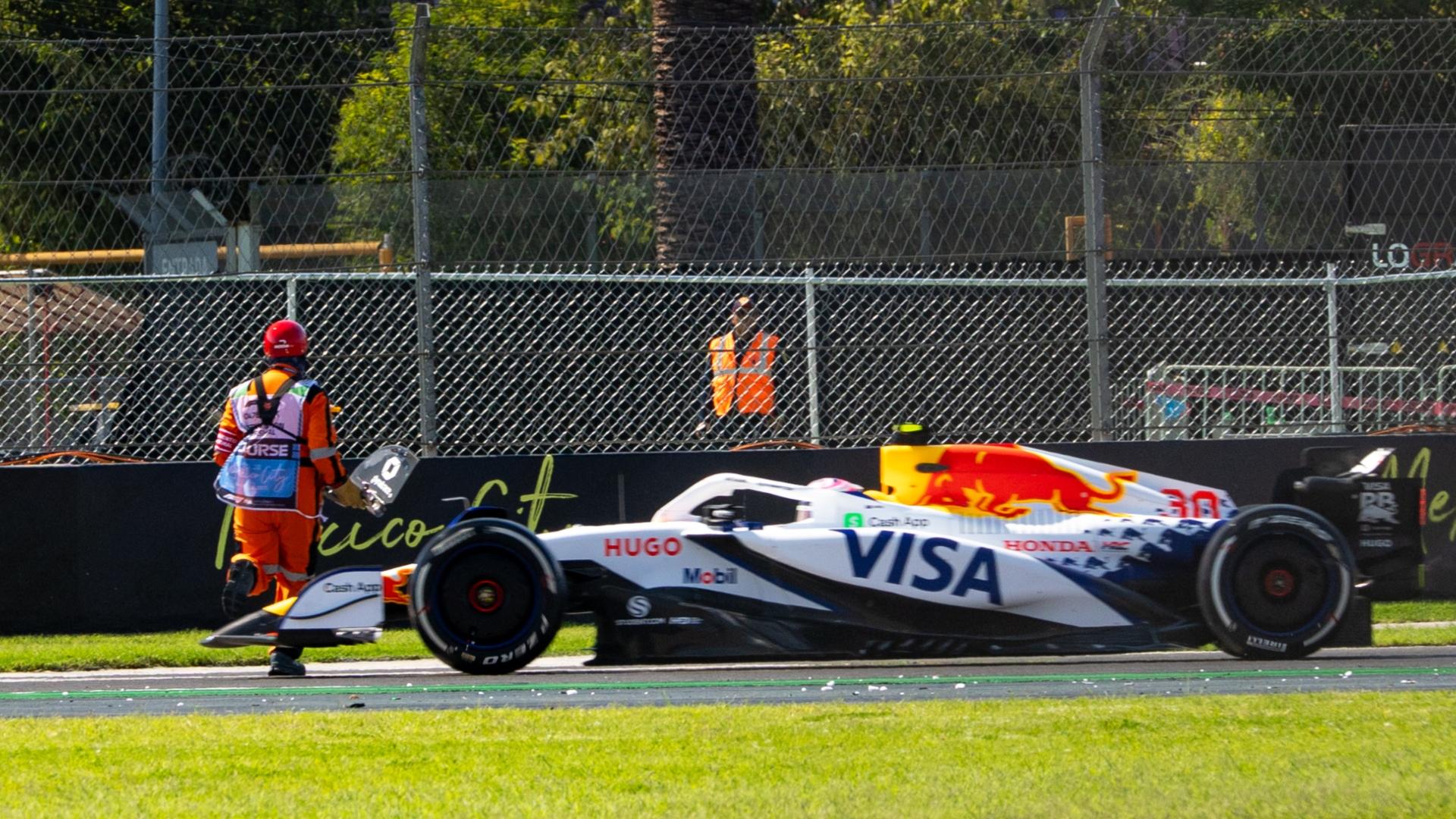 Liam Lawson narrowly avoids hitting marshals running across track